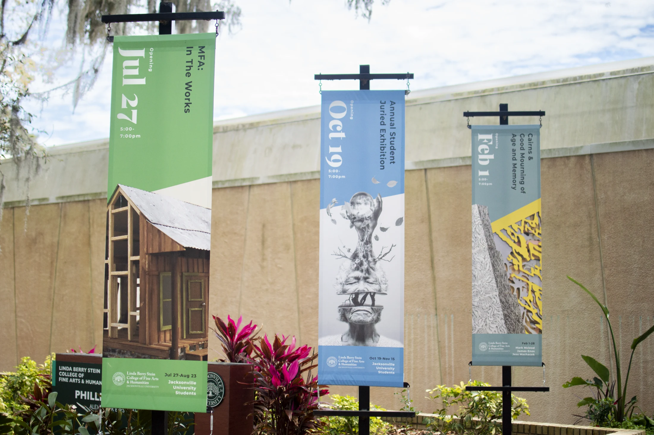 Three exhibition banners installed outside the Alexander Brest Gallery