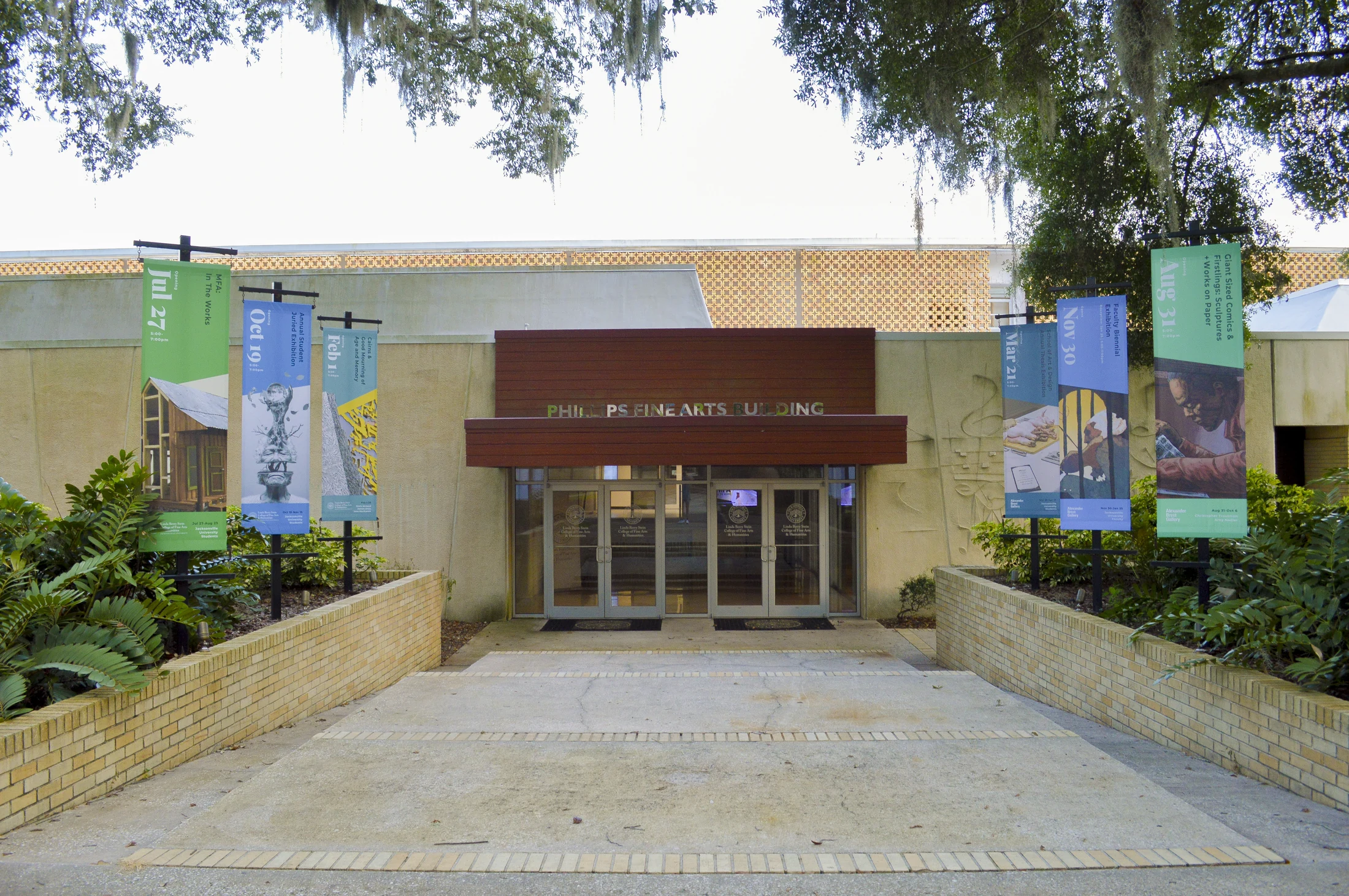 Six gallery banners lining the entrance to the fine arts building