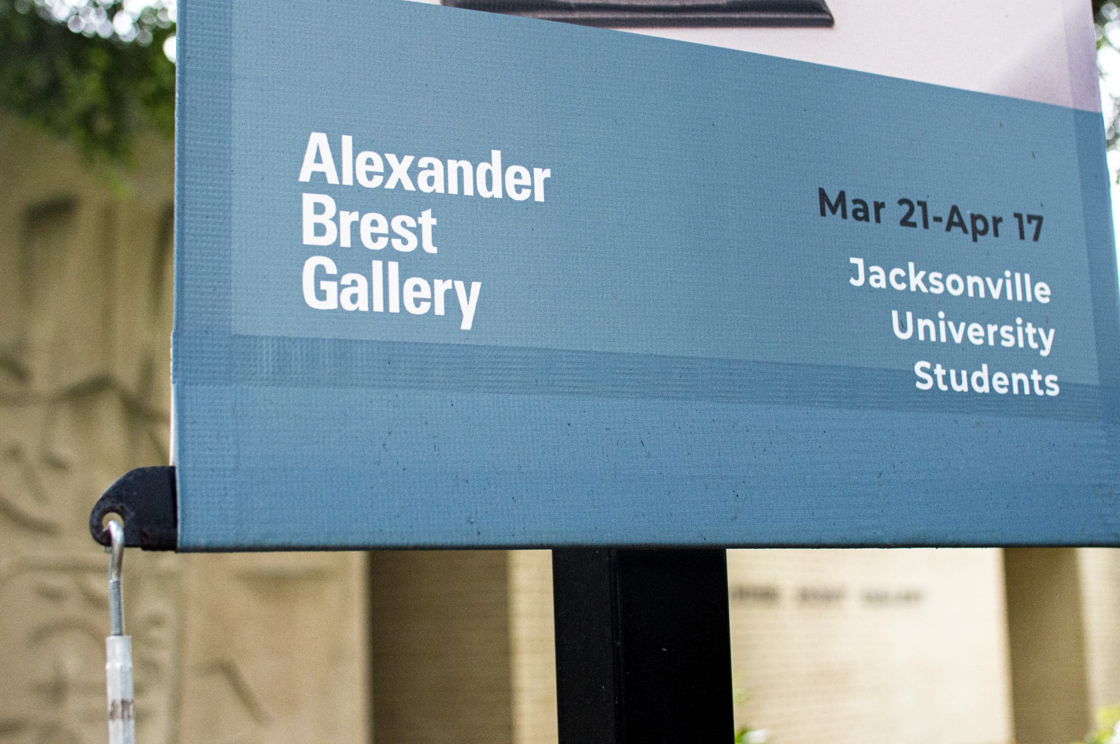 Blue Alexander Brest Gallery sign with exhibition dates